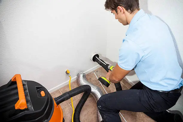 Technician performing dryer vent cleaning
